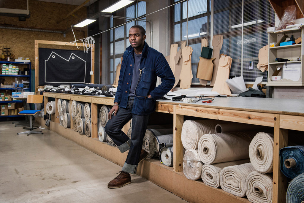 Blackhorse Lane, model wearing jeans in front of selvedge denim rolls